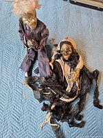 Both animated skeleton props displayed on blue quilted surface