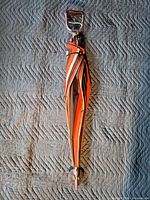 Full view closed umbrella showing striped canopy and seat handle