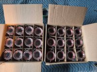 Two open cartons showing 24 glass clamp-lid jars in dividers