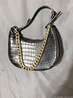 Front view showing crocodile texture and gold-tone chain