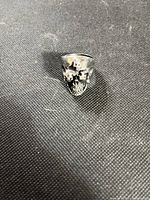 Front view showing multi-skull relief design on ring