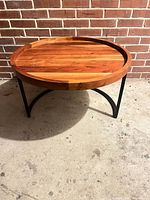 Full view of round coffee table against brick wall
