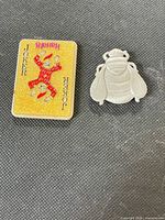 Harrah's Joker playing card magnet and metal bee magnet side by side