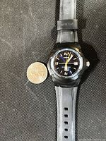Front view of Casio MW600F watch next to coin for scale