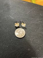 pair of crab stud earrings with quarter for scale