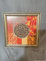 Front view of framed square wall art showing patchwork damask design and central medallion