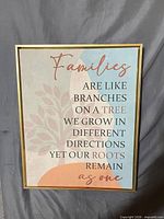 Full view of gold-framed wall art with family quote