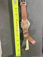 Full watch beside ruler showing overall length, brown leather strap