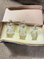 Box with foam insert holding three glass angel ornaments