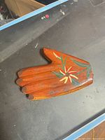 Front view showing carved fingers and floral painting