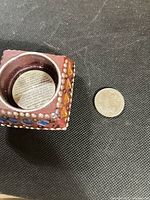 Top view showing tealight cavity, stud and gemstone decoration with coin for scale
