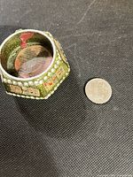 Top view of green glitter wooden tea light holder beside coin for scale