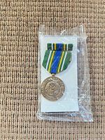 Medal and ribbon bar in sealed plastic on display card
