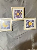 overall view of three framed prints on backdrop