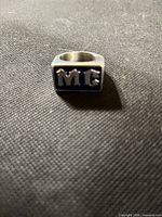 Ring front showing blue enamel face with MC letters