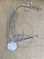 Full view of chrome spiral wine bottle holder showing coiled spring column, base ring and neck ring, tag attached