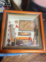 Front view of shadow box showing frame and miniature nautical items