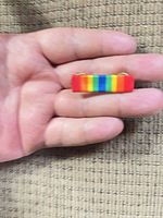 Front view of rainbow bar pin in hand
