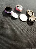Four stainless steel rings laid out showing finishes and size tags