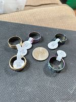 Five rings displayed around a quarter for scale with size tags visible