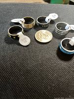 Five stainless steel rings with quarter for scale