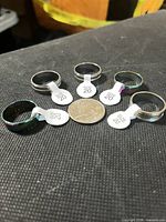 Six rings around a coin with size tags visible