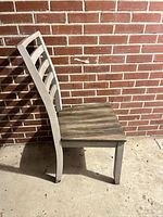 Side view of ladder-back dining chair showing two-tone finish