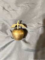 Front view of brass apple bell showing leaf handle
