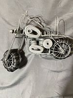 Full view of wire motorcycle figurine showing overall construction and color