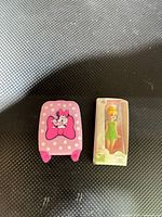 Tinker Bell miniature package and Minnie Mouse suitcase on black mat