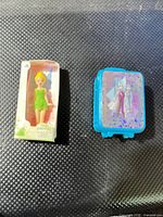 Tinker Bell boxed figure and Frozen suitcase side by side