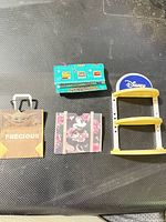 All four miniature accessories laid out: shelf, signage, Baby Yoda bag, Mickey tote