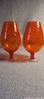 Two orange swirl glass goblets front view