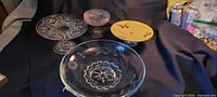 Four pedestal dishes—three glass, one yellow china—group view