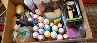 Top view of box with paints, sand jars, nutcracker, ribbon