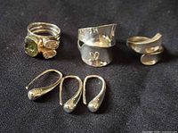 Group shot of all six sterling silver pieces: three rings and three earrings