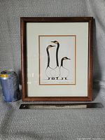Framed print beside soda can and ruler showing scale