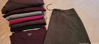 Stack of folded clothing with olive skort displayed