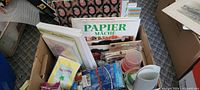 Full view of box with books, paper, cups, Velcro pack, and other supplies