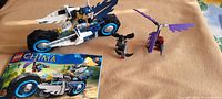 Overall lot showing twin bike, raven glider, minifigures, instruction booklet