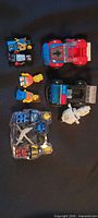 Overall lot showing loose minifigures, two vehicles, packaged minifigure set and horse