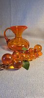 Amber glass pitcher and acrylic grape cluster together