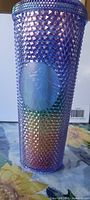 Front view of studded rainbow Starbucks cup showing embossed siren logo