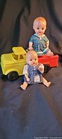 Overall lot showing truck and two dolls