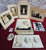 Group shot of all photographs and prints laid out on red surface