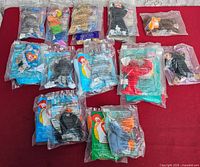 Back view of 13 sealed Teenie Beanie Babies bags on red surface