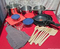Group shot of all cookware, storage, board, apron, utensils