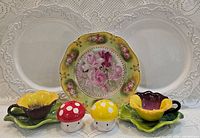 Group shot showing all items: two white plates, rose plate, two pansy cups on leaf saucers, two mushroom shakers