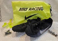 Shoes with drawstring bag, plastic bag of spikes, and spike tools