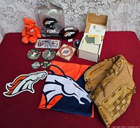 Entire lot laid out including Broncos items, baseball glove, slides box